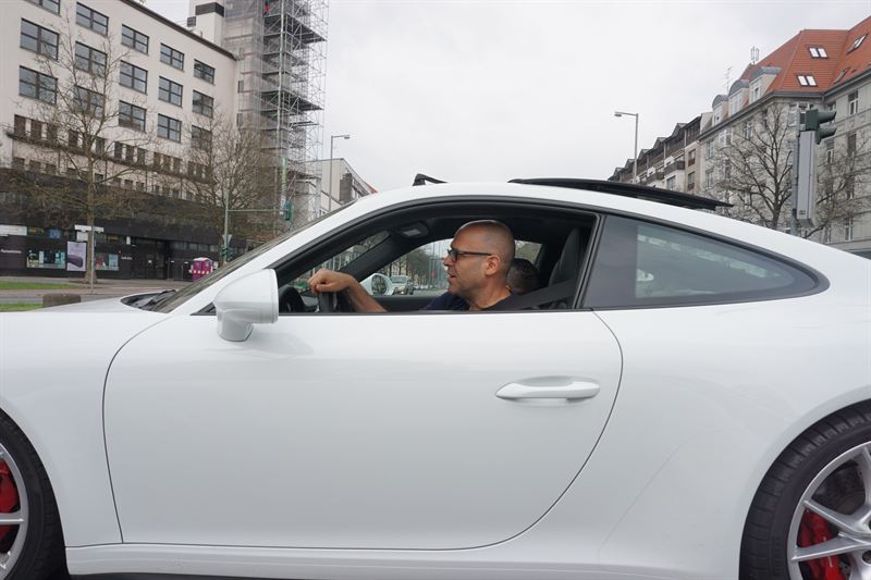 Niro Sharon in a white Porsche 911 GT3 on a Berlin street